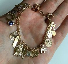 "18k gold filled charm (virgin mary,elephant,evil eye,hamsa,money bag,heart,crystal ,horseshoe cross)bracelet for good luck and protection..7.25\" long . pulsera de buena suerte en18k gold filled. para proteccion y buena suerte.7.25\" largo." Gold Jewelry Accessories, Money Bracelet, Horseshoe Cross, Xoxo Jewelry, Dope Jewelry Accessories, Evil Eye Hamsa, Teeth Jewelry, Wrist Jewelry, Heart Crystal