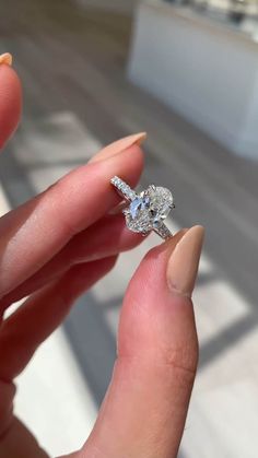 a woman's hand holding a diamond ring