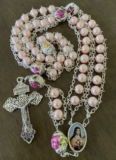 "This beautiful handmade rosary is made with 8mm pink glass beads, 10mm ceramic beads and 2\" Pardon crucifix. Length: 20\" inches long" Pink Bead Jewelry, Handmade Pink Rosary With Round Beads, Pink Beaded Spiritual Rosary, Pink Rosary With 8mm Round Beads, Pink Rosary With 8mm Beads For Gift, Pink Rosary With 8mm Beads As Gift, Pink Beaded Rosary With Round Beads, Handmade Pink Rosary For First Communion, Pink Spiritual Rosary Bracelet With 8mm Beads