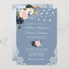 an elegant blue and white wedding card with flowers on the front, string lights in the background