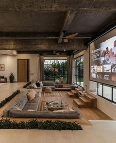 a large living room with couches and a flat screen tv on the wall above it