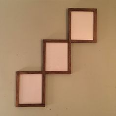 three wooden frames are hanging on the wall