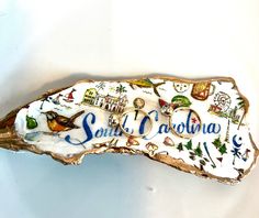 a piece of wood with the word santa barbara painted on it's side and images of birds