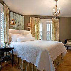 a bedroom with a large bed and chandelier