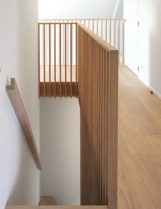 an empty staircase with wooden handrails and white walls