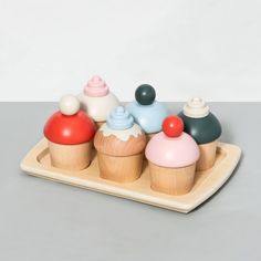 small wooden cupcakes with colorful frosting toppings on a serving platter