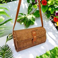 Hand-crafted from natural rattan, this rectangular handbag/clutch showcases a snap closure and adjustable crossbody strap for versatile use. Its fabric lining adds an extra touch of durability and versatility. Natural Rattan Size: Length: 8-1/8 | Depth: 3 inches | Height - 5 inches Snap Closure Rectangular Brown Strap Color: Natural Rectangular Straw Bag With Adjustable Strap, Travel Rectangular Straw Bag With Detachable Strap, Beach Crossbody Clutch With Adjustable Strap, Natural Rectangular Straw Bag With Detachable Strap, Rectangular Natural Straw Bag With Detachable Strap, Rectangular Clutch With Adjustable Strap, Daily Use Rectangular Clutch With Adjustable Strap, Rectangular Clutch With Leather Handles For Travel, Rectangular Clutch With Adjustable Strap For Daily Use