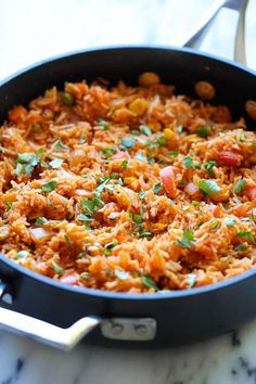 a pan filled with rice and vegetables on top of a stove