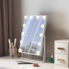 a vanity mirror with lights on it sitting next to a dresser and drawers in front of a window