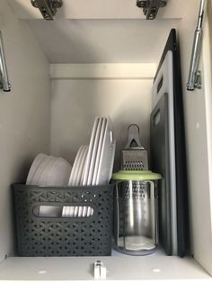 a kitchen cabinet with dishes and utensils in it