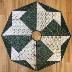 a green and white quilted table topper on a wooden floor with a circular hole in the center