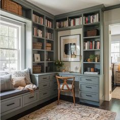 a home office with built - in bookshelves and drawers, along with a rug on the floor