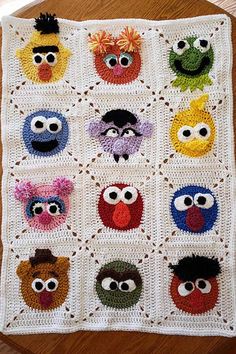 a crocheted blanket with many different faces on it