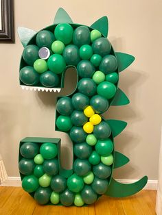 the letter e is made out of balloons with a green dragon on it's face