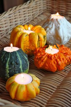 an image of pumpkins and candles on a wicker table