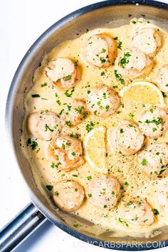 a skillet filled with shrimp and lemons on top of a white countertop