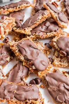 chocolate frosted cookies are arranged on a sheet of parchment paper and ready to be eaten