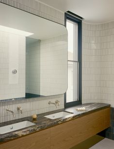 a bathroom with two sinks and a large mirror