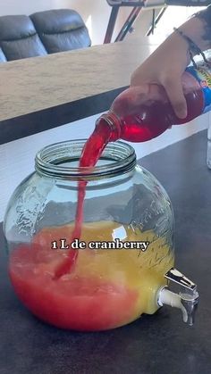 a person pouring liquid into a glass jar