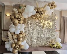 a large balloon arch with gold and white balloons