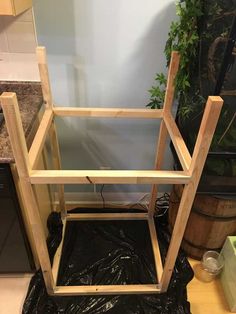 a wooden shelf sitting on top of a black plastic bag