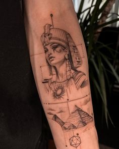 an egyptian tattoo on the arm with pictures and symbols in black and grey inks