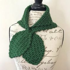 a mannequin wearing a green knitted scarf