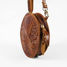 Embossed Leather Shoulder Round Bag Handmade Pyrography Floral Design Cross Body Saddle Vintage Handbag Height: 6.9 inches (15.5 cm) Width: 6.9 inches (15.5 cm) Depth: 1.4 inches (3.5 cm) Strap Length: max 56 inches (143 cm) This is a Handmade Cross-body Bag with a beautiful Floral Pyrography Design in Brown and Black color. It has one compartment and secures with a zipper. The strap is removable and adjustable for your shoulder. Natural vegetable tanned leather will age and darken with the sun Round Brown Shoulder Bag For Travel, Brown Round Shoulder Bag For Travel, Brown Round Bag For Daily Use, Artisan Brown Embroidered Shoulder Bag, Floral Pyrography, Bohemian Embroidered Leather Shoulder Bag, Brown Retro Shoulder Bag With Hand Tooled Details, Bohemian Brown Hand-tooled Shoulder Bag, Greek Mythology Statue