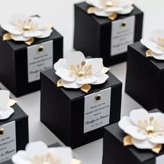 several black boxes with white and gold flowers on them