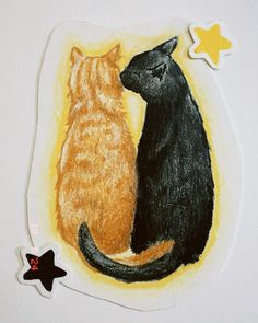 two cats sitting next to each other on top of a white surface with yellow stars