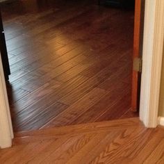 an open door leading to a living room with hard wood floors and hardwood flooring