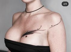 a woman with tattoos on her chest posing for the camera, wearing a black dress