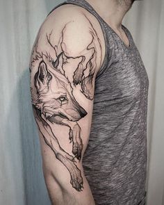 a man with a wolf tattoo on his arm