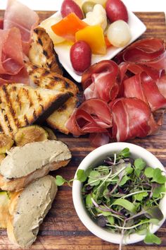 a wooden cutting board topped with different types of food