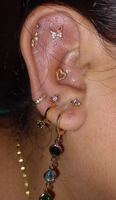 a close up of a person's ear with many different piercings on it