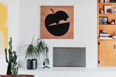 a living room filled with furniture next to a wall mounted painting on a white brick wall