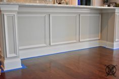 an empty kitchen with white cabinets and wood floors