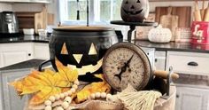 a kitchen filled with lots of decorations and pumpkins on top of a counter next to a clock