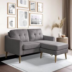 a living room with a gray sectional couch and pictures on the wall above it, along with a white rug