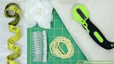 scissors, measuring tape and other craft supplies laid out on top of a cutting board