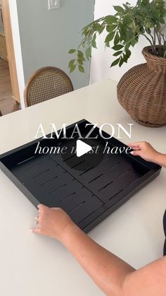 a woman sitting at a table with an amazon home is not have sign in front of her