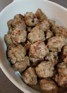 a white bowl filled with meatballs on top of a table