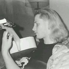 black and white photograph of a woman holding a hair dryer in her right hand