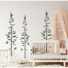 a baby's room with trees painted on the wall and a crib in the foreground