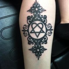 a black and white photo of a tattoo on someone's leg with an inverted symbol in the middle