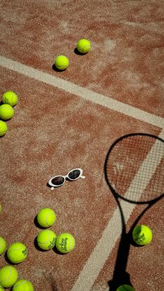 tennis balls and rackets are scattered on the court