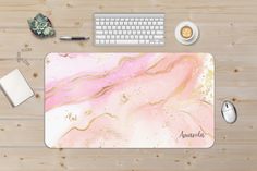 a pink marble mouse pad sitting on top of a wooden desk next to a keyboard