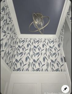 the ceiling is decorated with blue and white wallpaper, which has leaves on it