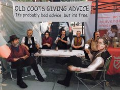 a group of people sitting around a table with a sign on it that says old cots giving advice