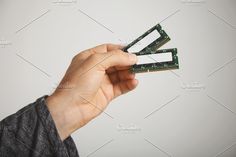 a man holding three memory cards in one hand and another on the other with their fingers